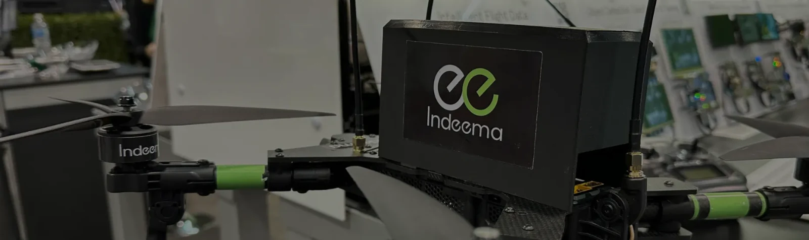 A drone frame on an engineering bench with an Indeema-branded electronics enclosure mounted on it