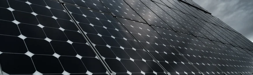 Close-up of a solar panel surface under a cloudy sky