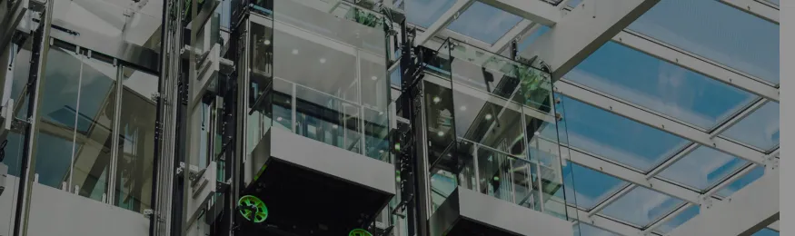 Glass elevator shafts rising through an office atrium