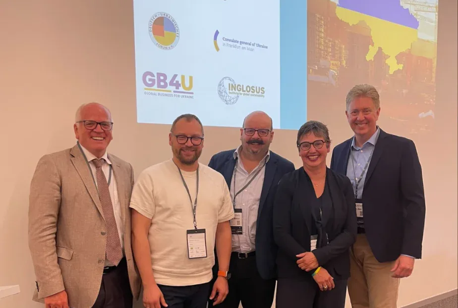Five conference attendees in front of a slide with GB4U, INGLOSUS and Consulate General of Ukraine in Frankfurt logos