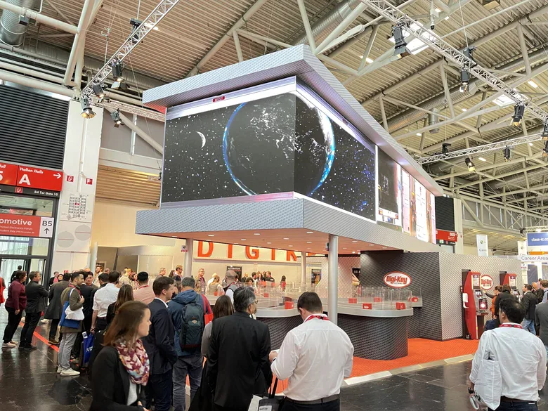 Digi-Key stand with a large overhead LED screen showing Earth from space, surrounded by a crowd of visitors