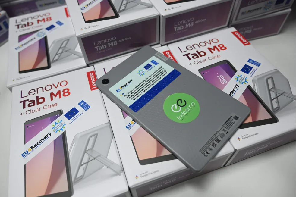 Lenovo Tab M8 tablet with an Indeema sticker and EU4Recovery label lying on boxed tablets marked with EU and UNDP logos