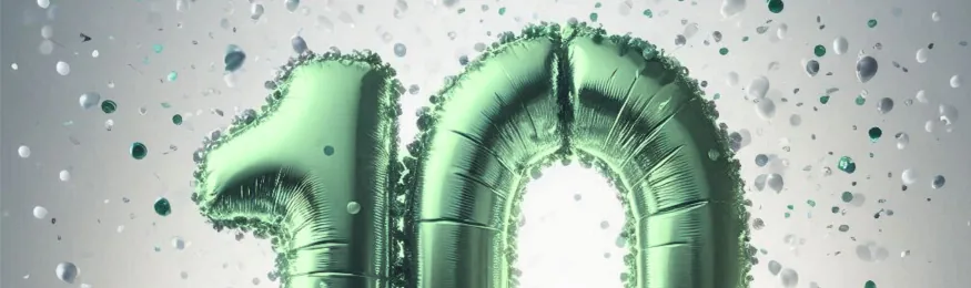 Green foil balloons forming the number 10 surrounded by falling confetti