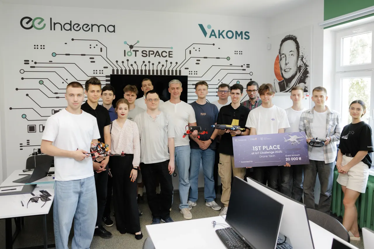 Student teams and organizers of IoT Challenge 2025: Drone Tech in the IoT laboratory, holding their drones and the first-place certificate.