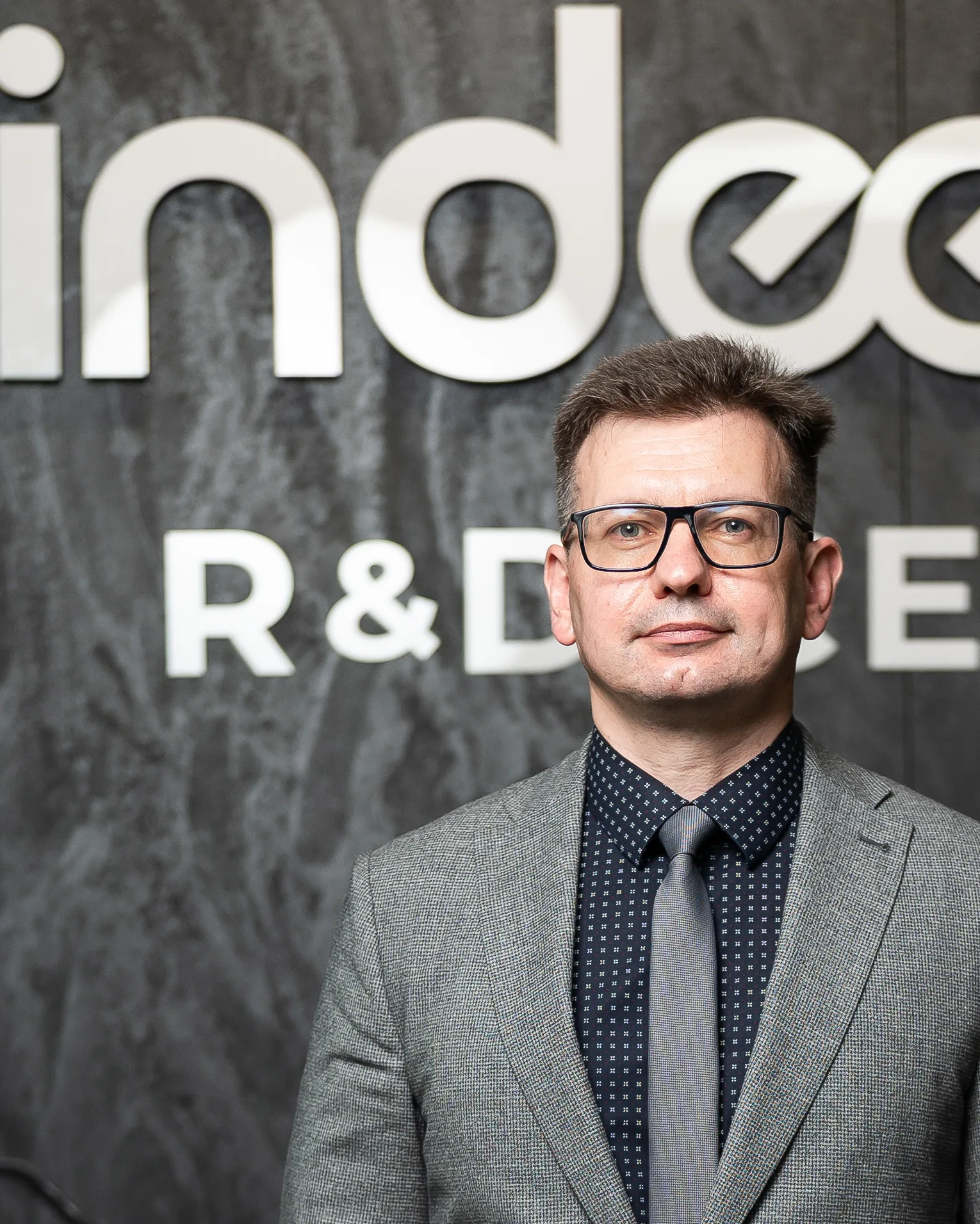 Dr. Ivan Karbovnyk, CTO of Indeema, standing in front of the Indeema R&D Center wall